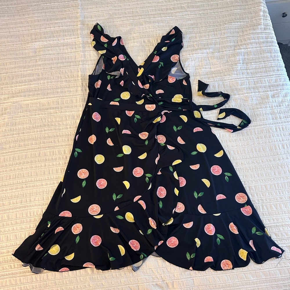 Plus-sized black wrap dress with fruit graphic.